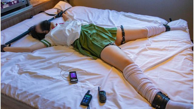 A girl in a green uniform is tied up and subjected to electric shock (Rko)